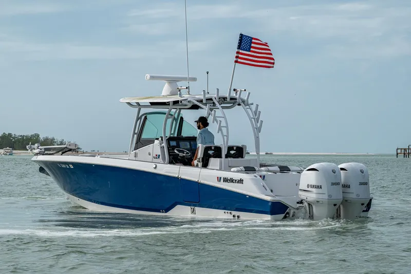  Yacht Photos Pics 2020 Wellcraft 302 Fisherman boat with dual engines and American flag on open water.