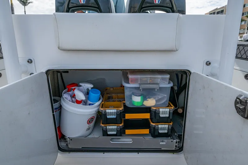  Yacht Photos Pics Storage compartment on a 2020 Wellcraft 302 Fisherman boat, organized with fishing gear and supplies.