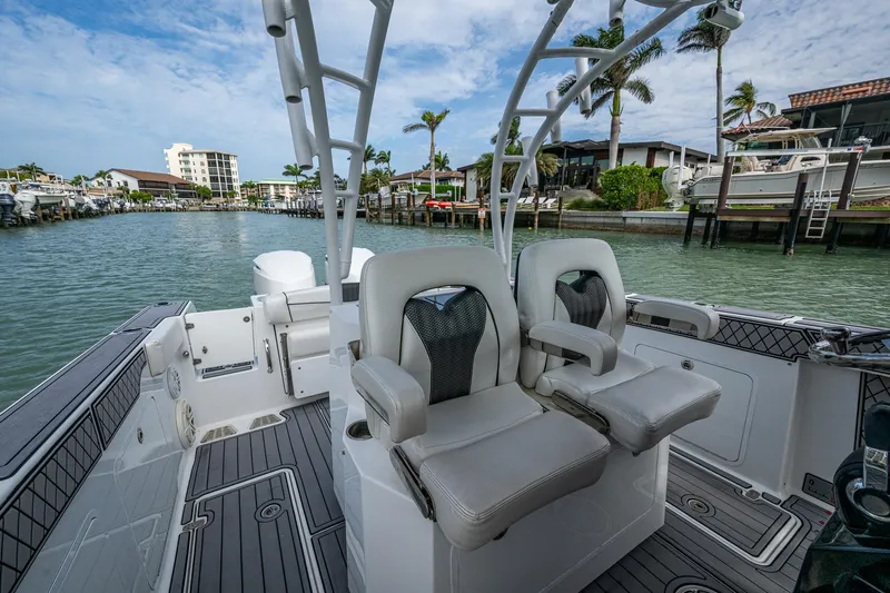  Yacht Photos Pics 2020 Wellcraft 302 Fisherman boat interior with dual seats, docked in a scenic marina.