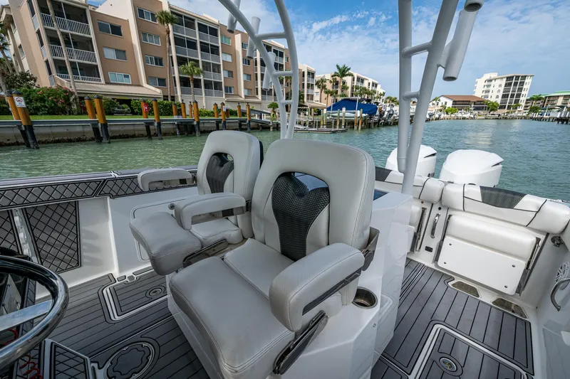  Yacht Photos Pics 2020 Wellcraft 302 Fisherman boat interior with luxury seating, docked near waterfront buildings.