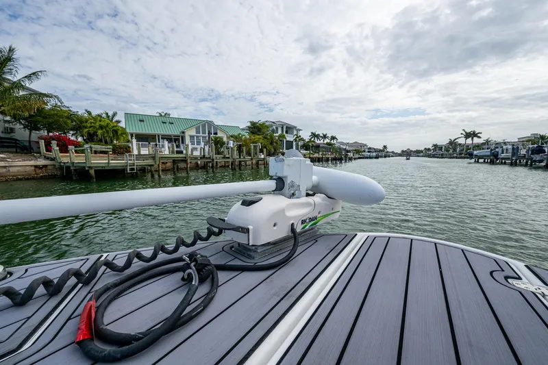  Yacht Photos Pics 2020 Wellcraft 302 Fisherman boat docked near waterfront homes under cloudy sky.