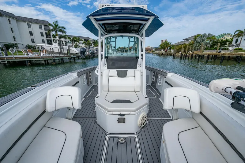  Yacht Photos Pics 2020 Wellcraft 302 Fisherman boat with sleek interior, docked in a scenic marina.