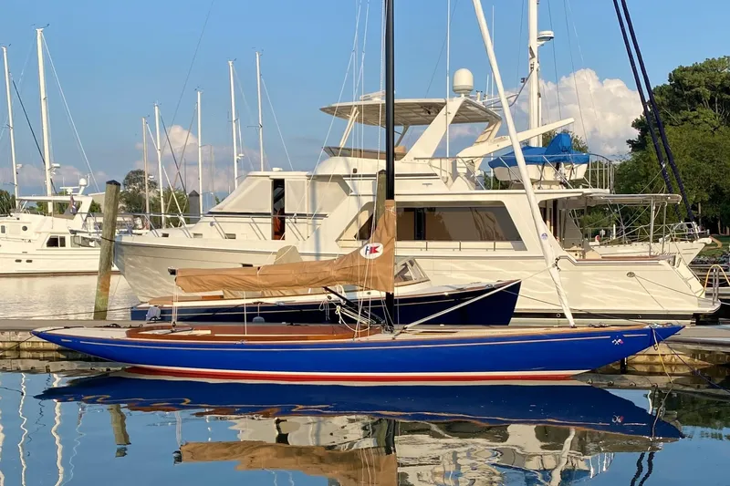 Caprice Yacht Photos Pics 2023 C.W. Hood 32 Daysailer docked at marina, blue hull, tan sail, calm water.