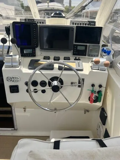 My Turn Yacht Photos Pics Control panel of a 2002 Carolina Classic 35 Express boat with steering wheel and navigation equipment.