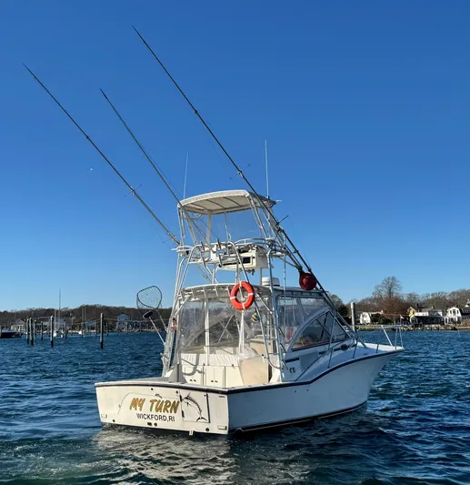 My Turn Yacht Photos Pics 2002 Carolina Classic 35 Express boat on water, clear sky, fishing rods visible.