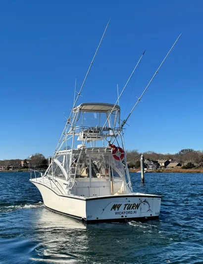 My Turn Yacht Photos Pics 2002 Carolina Classic 35 Express boat on water, clear sky, rear view.