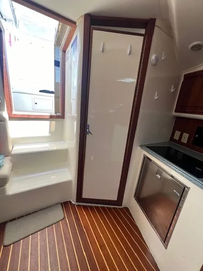My Turn Yacht Photos Pics Interior of 2002 Carolina Classic 35 Express boat with wooden flooring and compact kitchen area.