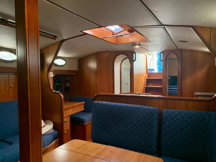 Ariadne Yacht Photos Pics Luxurious interior of 2004 ShearWater 45 yacht with wooden finish and blue seating.