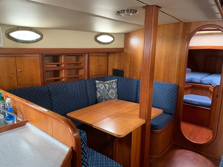 Ariadne Yacht Photos Pics Luxurious ShearWater 45 yacht interior, featuring a cozy dining area with blue upholstered seating.