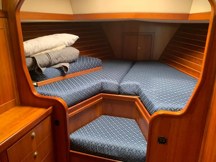 Ariadne Yacht Photos Pics Cozy cabin interior of 2004 ShearWater 45 yacht with blue bedding and wooden finish.