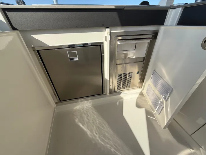 Wild Aces Yacht Photos Pics 2022 Absolute 64 Navetta yacht interior with stainless steel appliances and storage compartments.