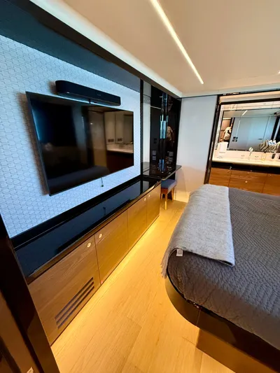 Wild Aces Yacht Photos Pics Luxurious bedroom interior of 2022 Absolute 64 Navetta yacht with modern TV and elegant decor.
