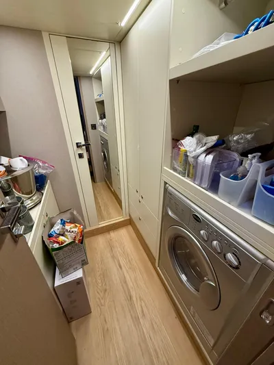 Wild Aces Yacht Photos Pics Laundry area in 2022 Absolute 64 Navetta yacht with washer, shelves, and storage.
