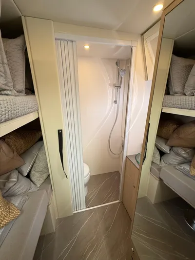 Wild Aces Yacht Photos Pics Interior of 2022 Absolute 64 Navetta yacht with compact bathroom and cozy bunk beds.