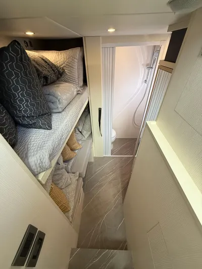 Wild Aces Yacht Photos Pics Interior of 2022 Absolute 64 Navetta yacht with cozy bunk beds and modern bathroom.