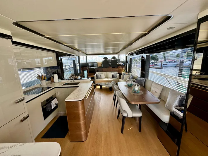 Wild Aces Yacht Photos Pics Luxurious interior of 2022 Absolute 64 Navetta yacht with modern kitchen and dining area.