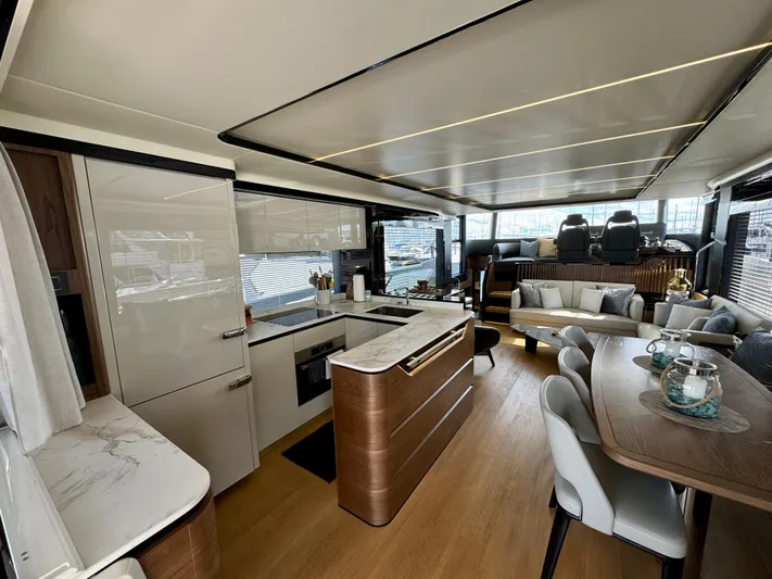 Wild Aces Yacht Photos Pics Luxurious interior of 2022 Absolute 64 Navetta yacht with modern kitchen and seating area.