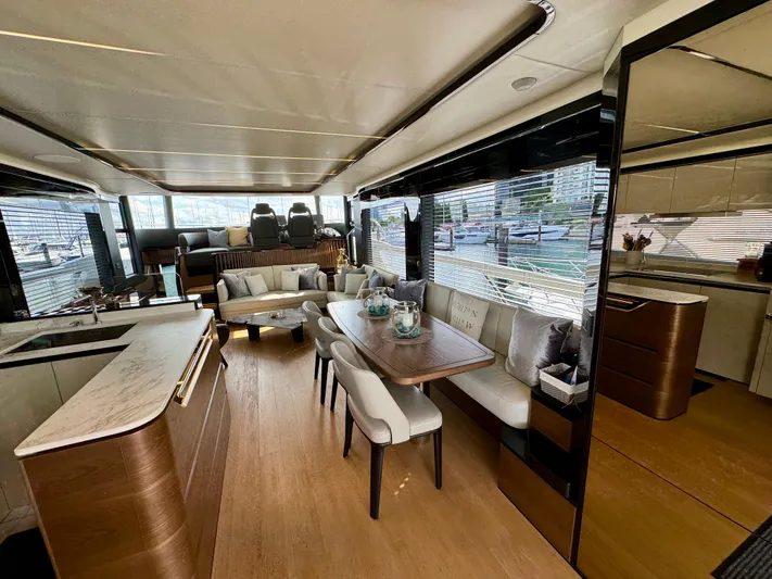 Wild Aces Yacht Photos Pics Luxurious interior of 2022 Absolute 64 Navetta yacht with elegant dining and seating area.