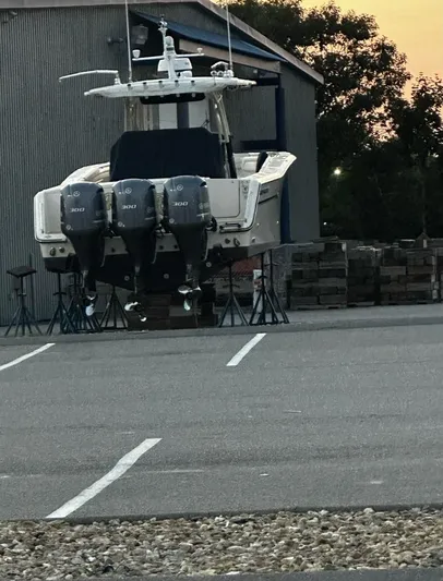 Yacht Photos Pics 2018 Grady-White Canyon 336 boat with triple engines on stands in a parking area.