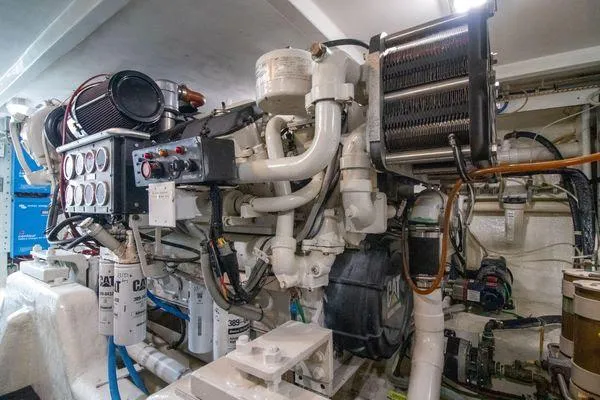 Slick Nickel Yacht Photos Pics Engine room of a 2000 Bertram CNV boat with complex machinery and piping.