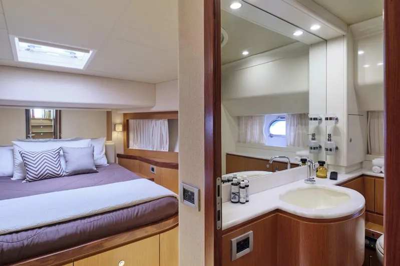 M/y Flow Yacht Photos Pics Luxurious bedroom and bathroom interior of 2008 Ferretti 681 yacht, featuring elegant wood finishes.