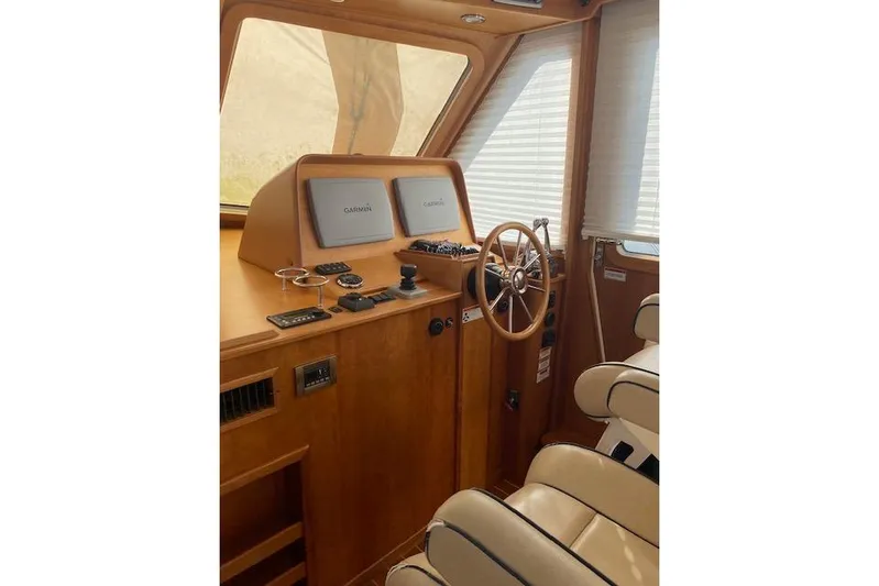  Yacht Photos Pics 2010 Sabre 38 Express helm with Garmin navigation, wooden steering wheel, and beige seating.