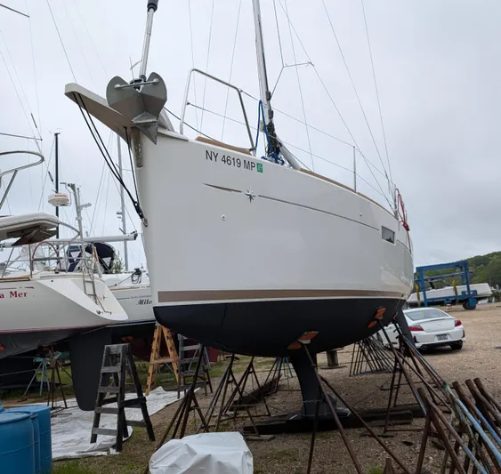  Yacht Photos Pics 2021 Jeanneau Sun Odyssey 349 sailboat on stands, marina background, overcast sky.