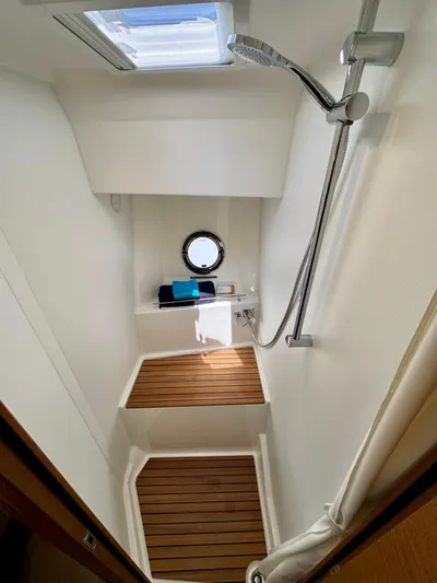  Yacht Photos Pics 2025 Beneteau Swift Trawler 41 Fly shower with wooden flooring and modern fixtures.