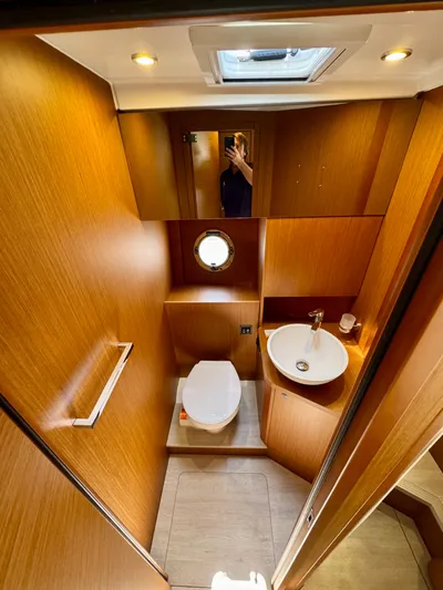  Yacht Photos Pics 2025 Beneteau Swift Trawler 41 Fly bathroom with wood finish, skylight, and porthole window.