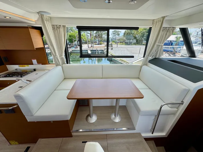  Yacht Photos Pics Interior of 2025 Beneteau Swift Trawler 41 Fly with white seating and wooden table.