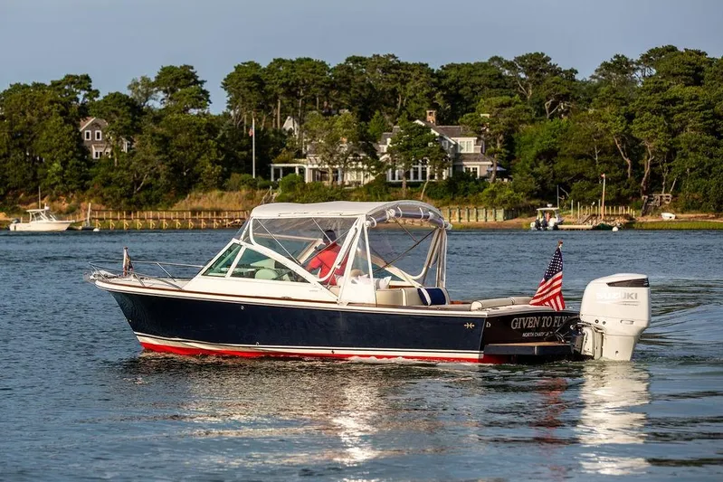 Given To Fly Yacht Photos Pics 2021 Hunt Yachts Harrier 26 boat on water, American flag, scenic background.