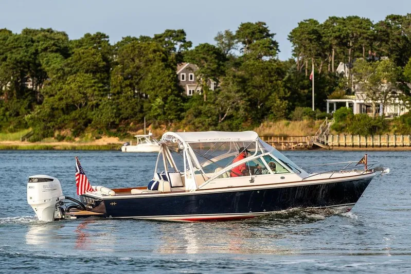 Given To Fly Yacht Photos Pics 2021 Hunt Yachts Harrier 26 cruising on a scenic waterway with lush greenery.