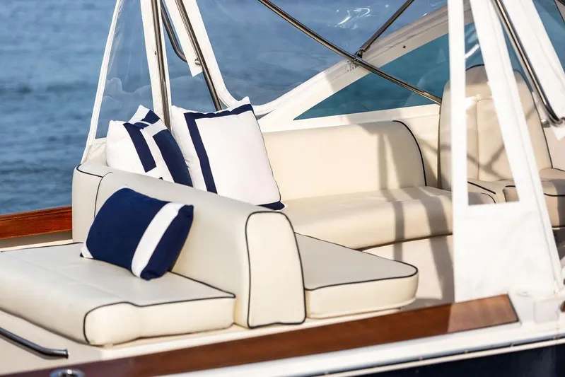Given To Fly Yacht Photos Pics 2021 Hunt Yachts Harrier 26 interior with elegant cream seating and nautical-themed cushions.