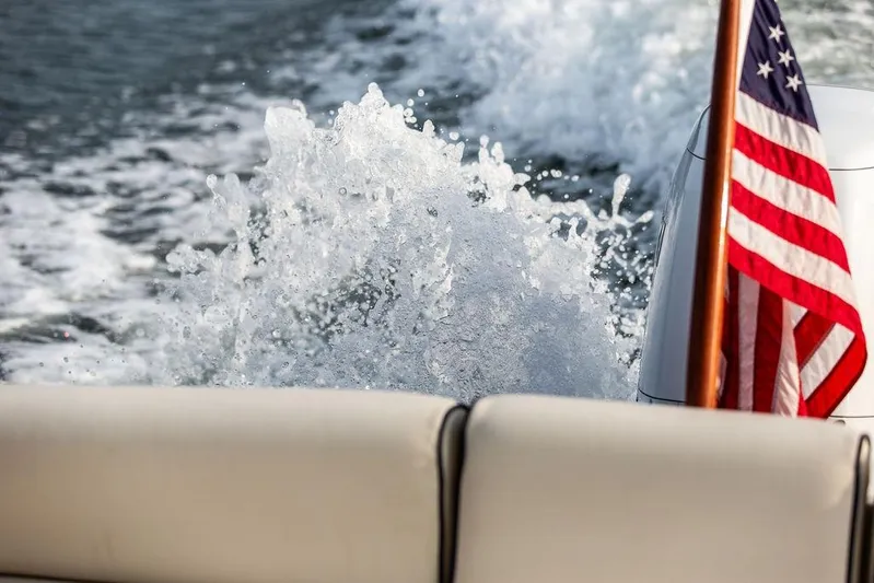 Given To Fly Yacht Photos Pics American flag on 2021 Hunt Yachts Harrier 26, with water splashing behind.