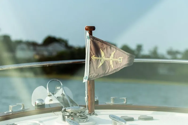 Given To Fly Yacht Photos Pics 2021 Hunt Yachts Harrier 26 with flag on deck, scenic water background.