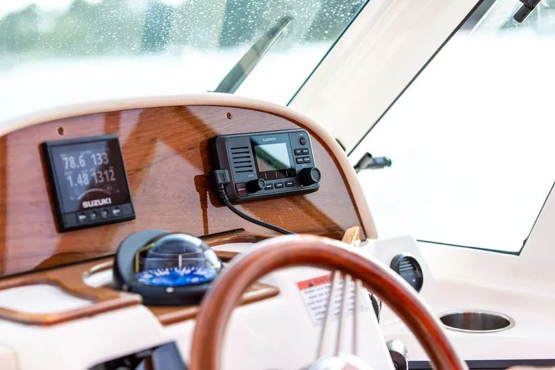 Given To Fly Yacht Photos Pics 2021 Hunt Yachts Harrier 26 dashboard with navigation instruments and wooden steering wheel.