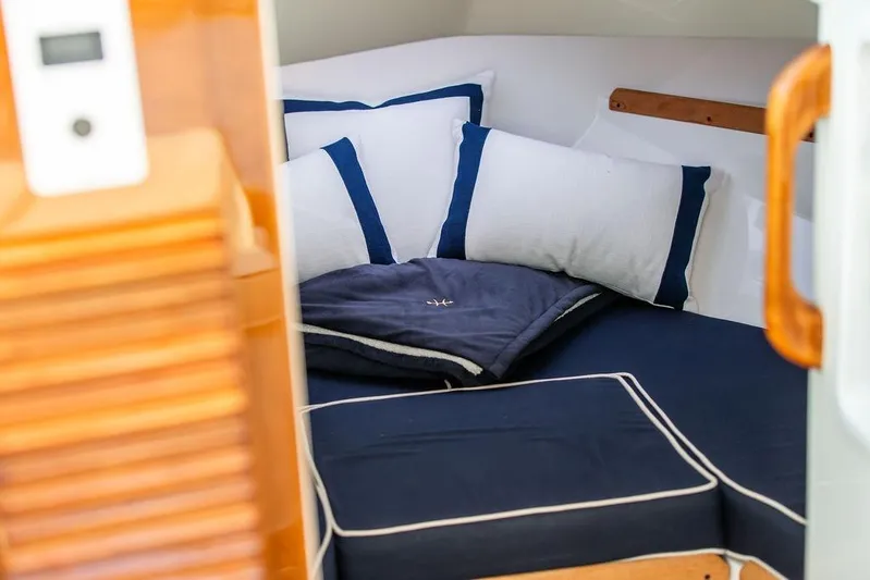 Given To Fly Yacht Photos Pics Cozy cabin interior of 2021 Hunt Yachts Harrier 26 with navy and white bedding.