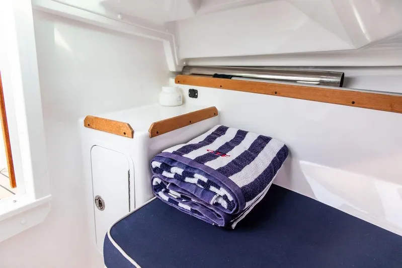 Given To Fly Yacht Photos Pics 2021 Hunt Yachts Harrier 26 interior with striped towel and seating area.