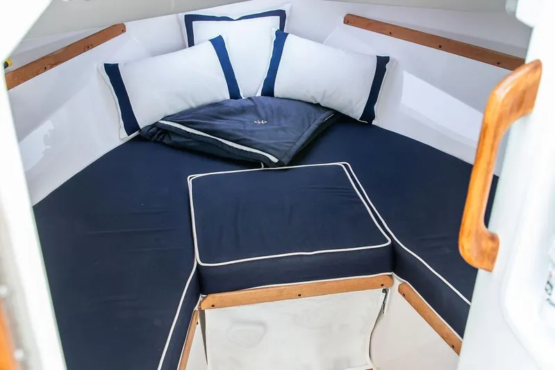 Given To Fly Yacht Photos Pics 2021 Hunt Yachts Harrier 26 cabin with navy cushions and wooden accents.
