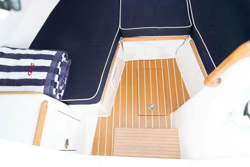 Given To Fly Yacht Photos Pics 2021 Hunt Yachts Harrier 26 interior with striped towel and wooden flooring.