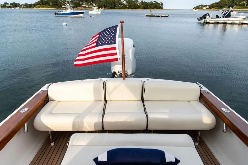 Given To Fly Yacht Photos Pics 2021 Hunt Yachts Harrier 26 with American flag, docked in serene waters.