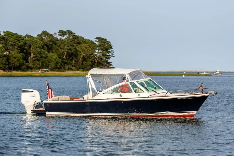 Given To Fly Yacht Photos Pics 2021 Hunt Yachts Harrier 26 cruising on a serene lake with lush green shoreline.