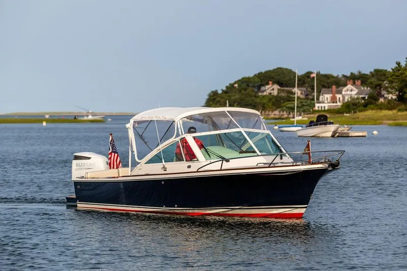Given To Fly Yacht Photos Pics 2021 Hunt Yachts Harrier 26 cruising on a serene waterway with scenic background.