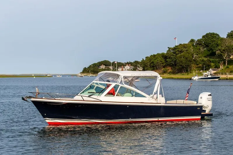 Given To Fly Yacht Photos Pics 2021 Hunt Yachts Harrier 26 cruising on a serene lake with scenic background.