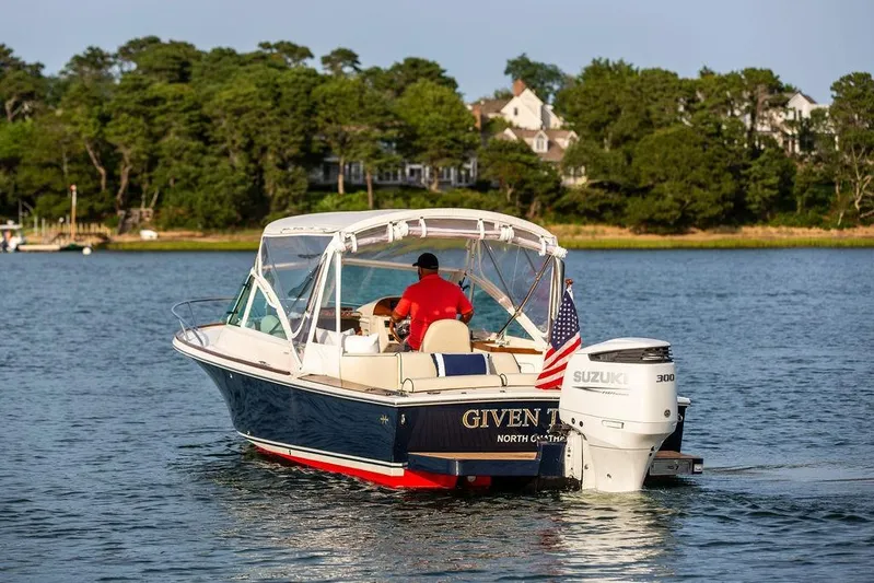 Given To Fly Yacht Photos Pics 2021 Hunt Yachts Harrier 26 cruising on a serene lake with lush greenery.