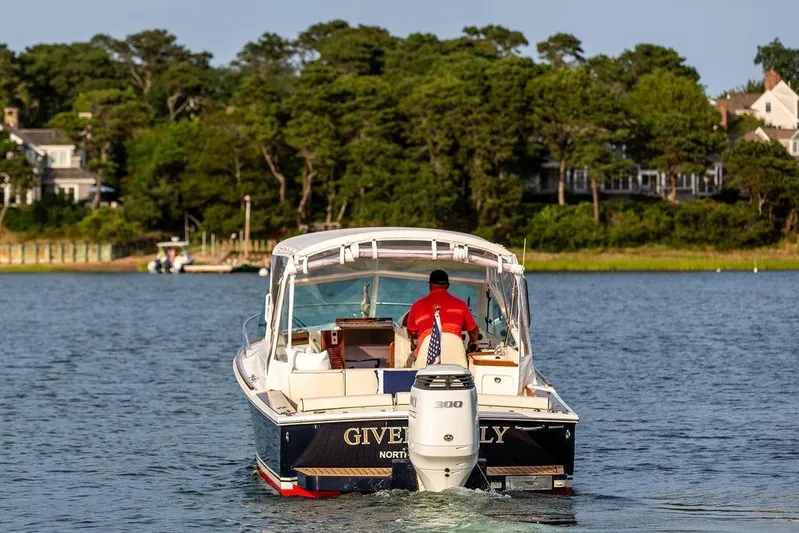 Given To Fly Yacht Photos Pics 2021 Hunt Yachts Harrier 26 cruising on a serene lake with lush greenery in the background.