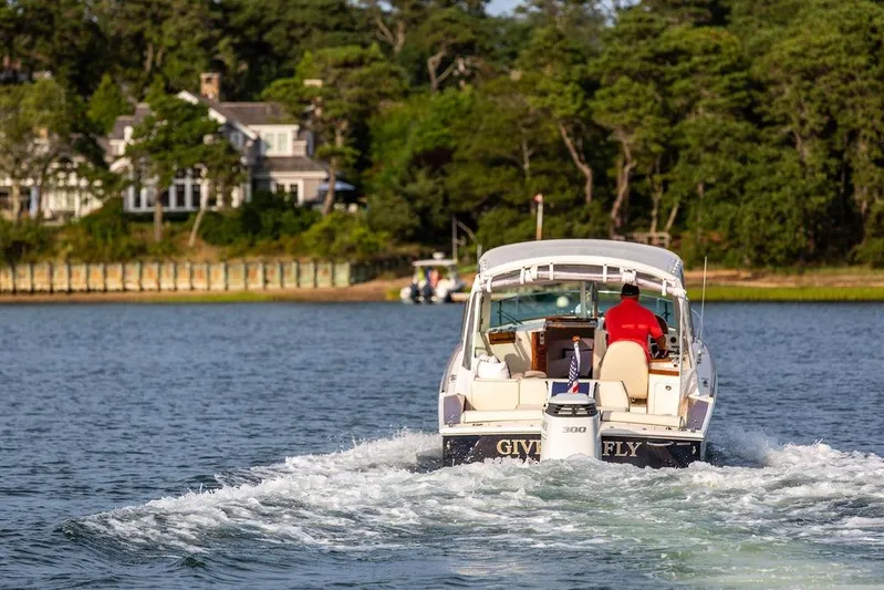 Given To Fly Yacht Photos Pics 2021 Hunt Yachts Harrier 26 cruising on a scenic lake with lush greenery.