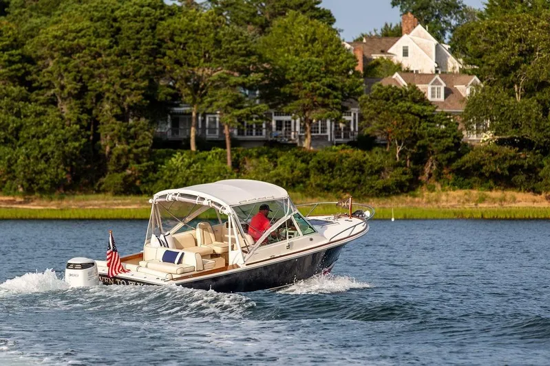 Given To Fly Yacht Photos Pics 2021 Hunt Yachts Harrier 26 cruising on a scenic lake with lush greenery.