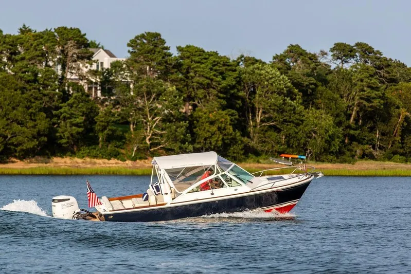 Given To Fly Yacht Photos Pics 2021 Hunt Yachts Harrier 26 cruising on a scenic lake with lush greenery.