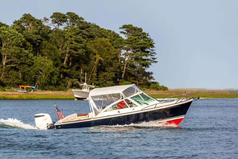 Given To Fly Yacht Photos Pics 2021 Hunt Yachts Harrier 26 cruising on a scenic lake with lush greenery.